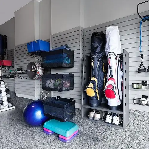 Garage gym slatwall and pegboard organizing resistance bands, jump ropes, and workout accessories.