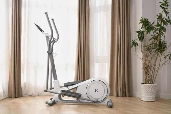 Compact elliptical trainer in a modern apartment home gym for low-impact cardiovascular exercise.
